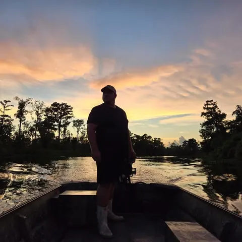 ZZ standing in his boat at sunset on the bayou