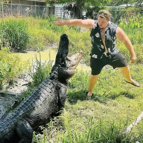 ZZ facing off with a large alligator rearing out of the water